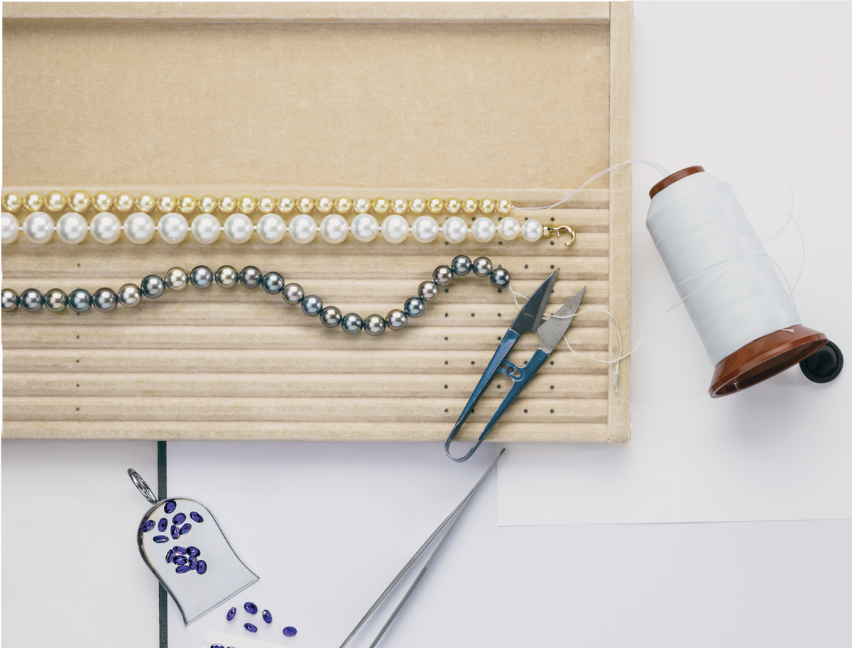 Jewelry-making tools and materials on a white surface