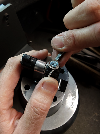 Person crafting an engagement ring with a focus on precision.