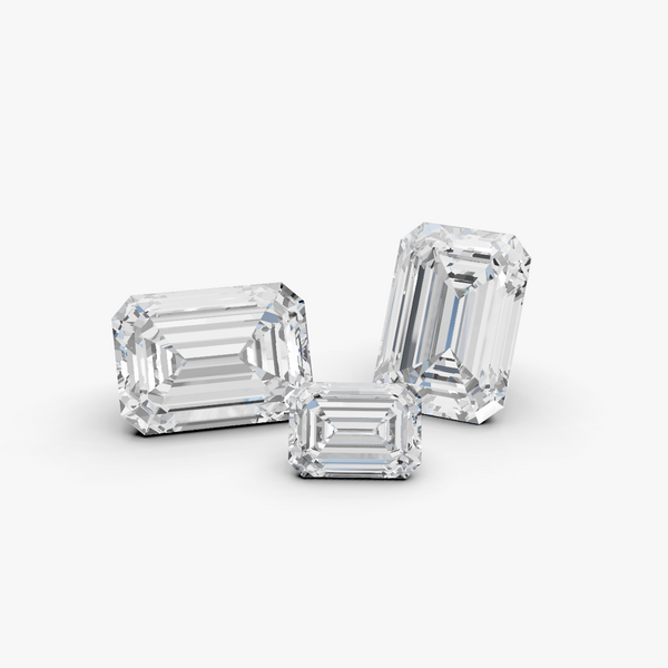 Three emerald-cut diamonds on a gray background