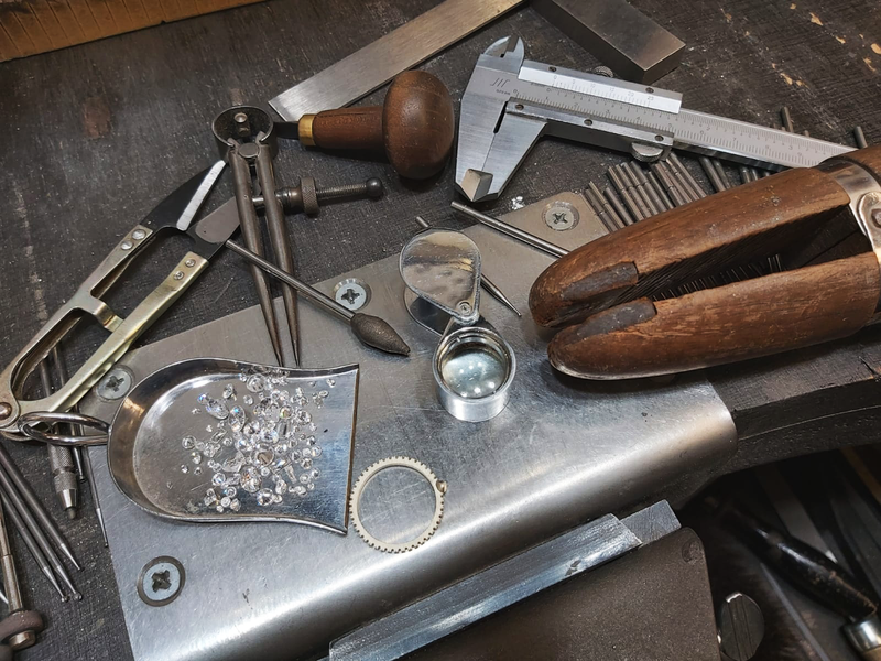 Collection of jewelry-making tools on a workbench