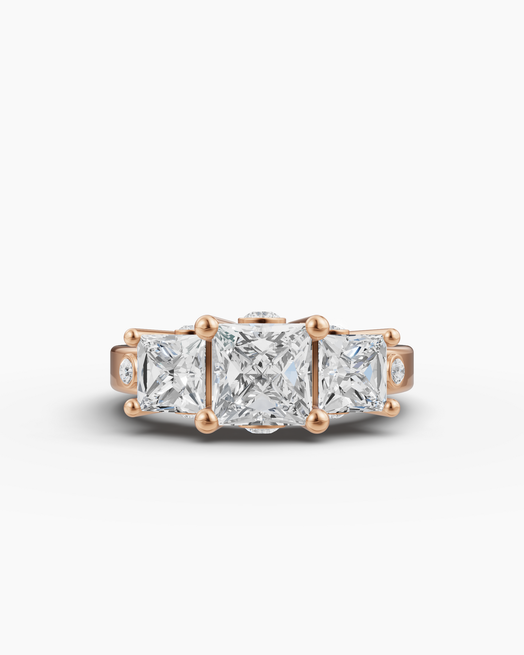 Gold ring with three square-cut diamonds on a white background