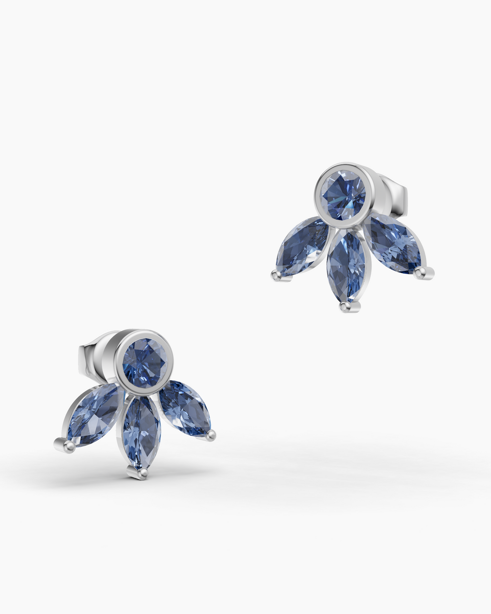 Pair of silver earrings with blue gemstones on a white background