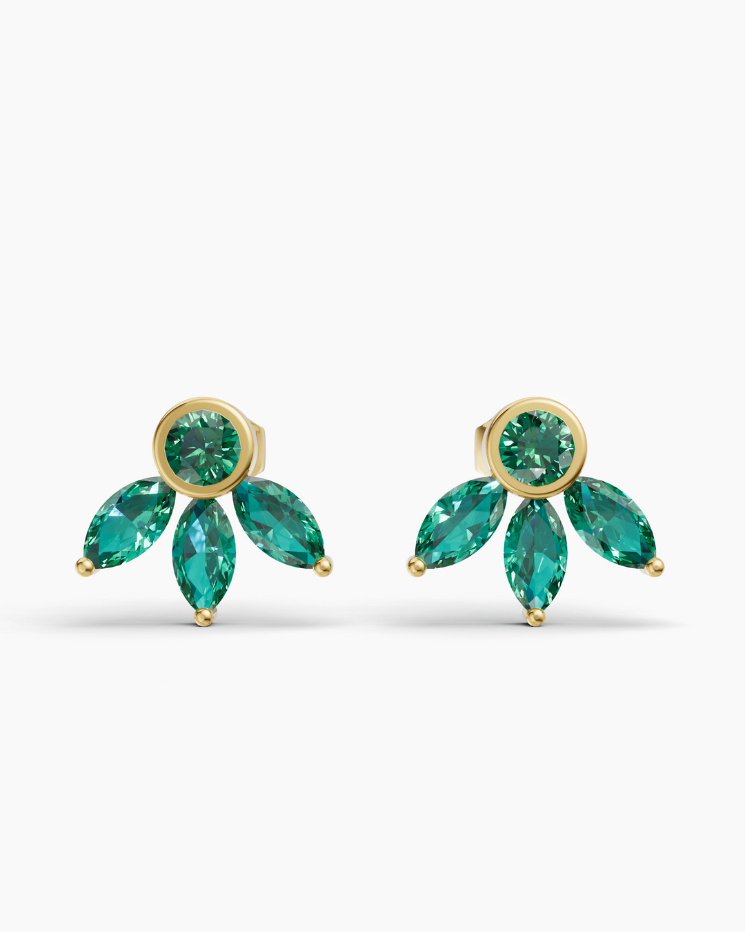 Gold earrings with green gemstones on a white background