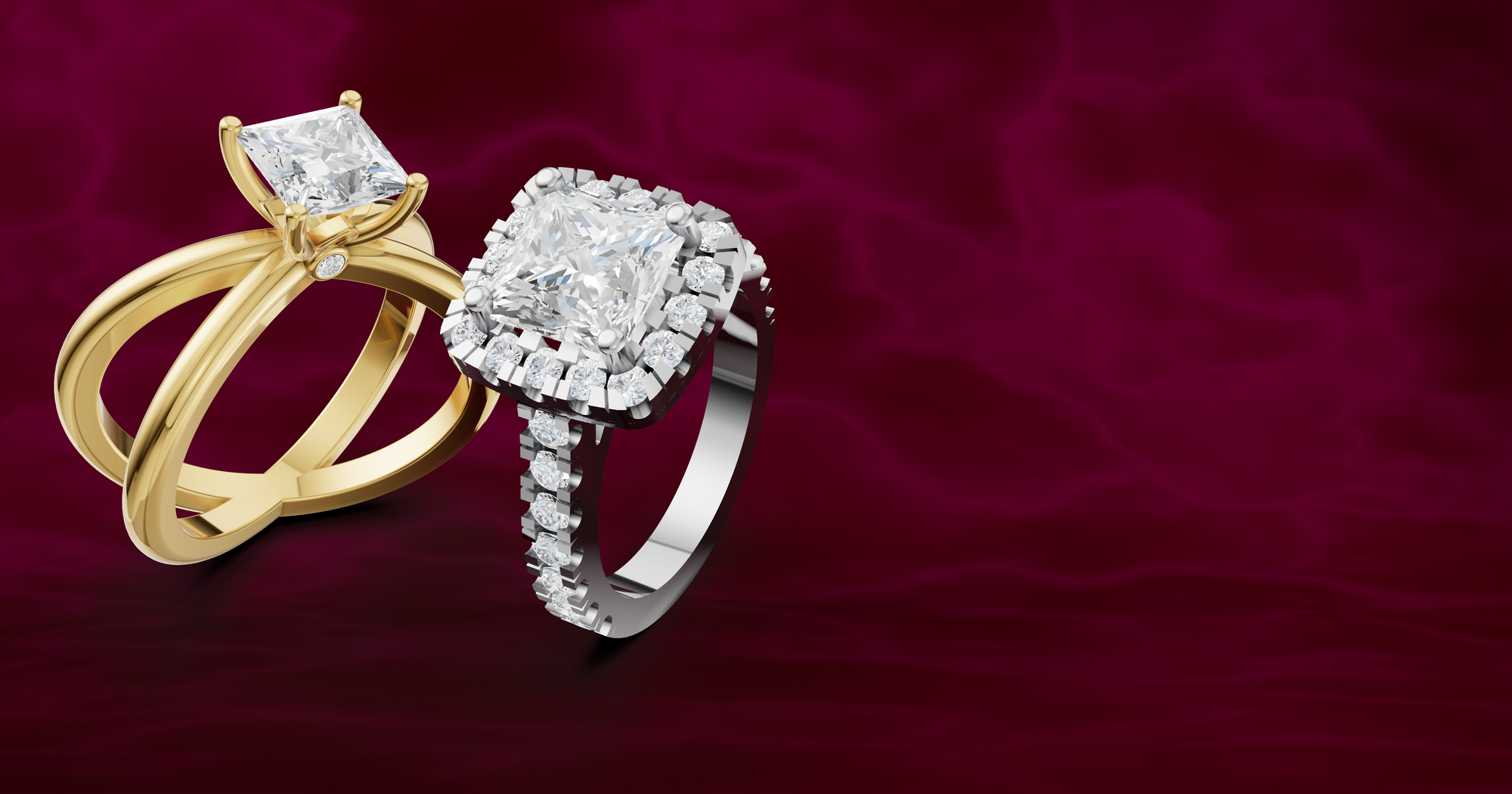 Two diamond rings, one gold and one white gold, on a dark red background