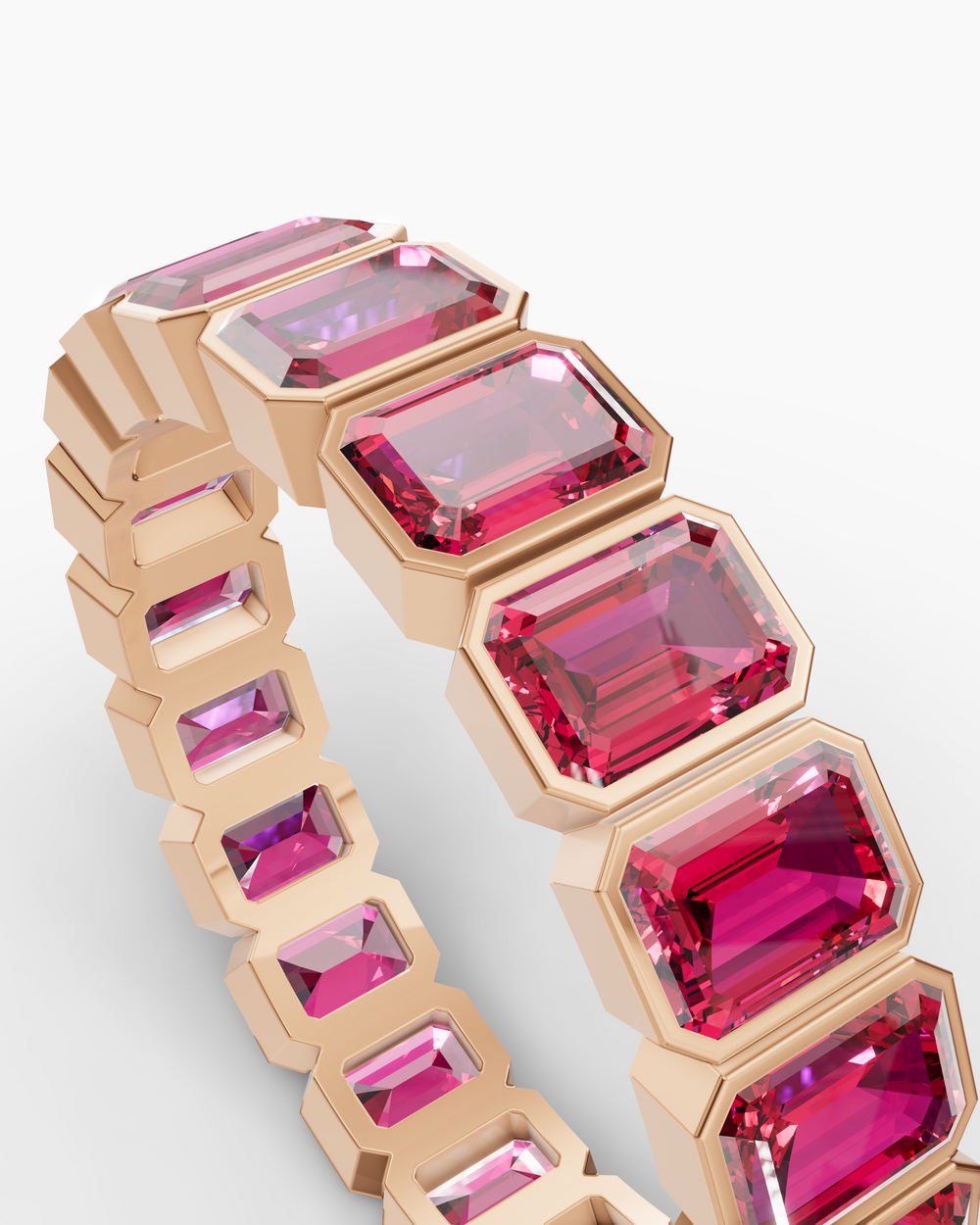 Jewelry with pink gemstones and gold accents on a light gray background