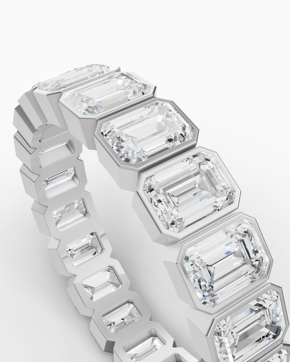 Diamond ring with emerald-cut stones on a white background