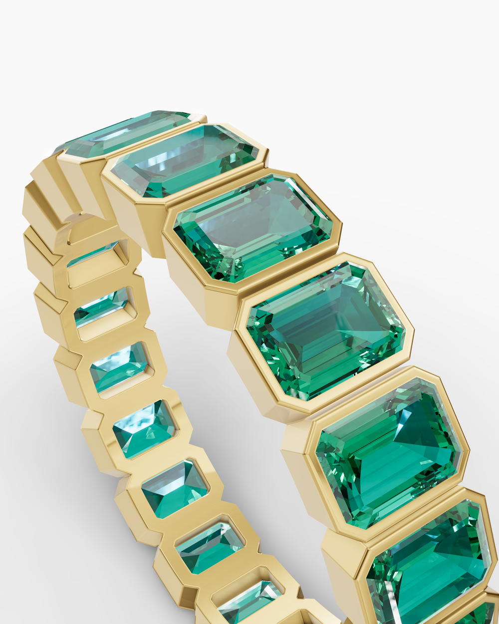 Gold bracelet with green gemstones on a white background